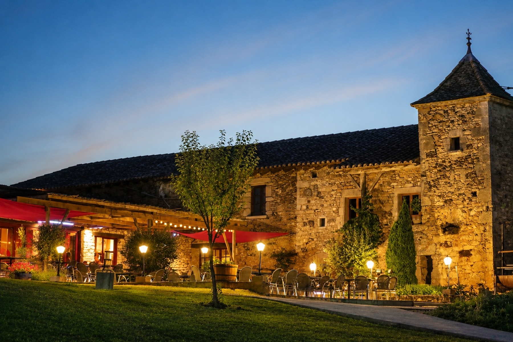 Cour en pierre et terrasse éclairée du camping
